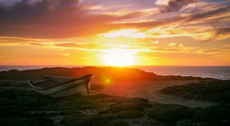 Weicher Sonnenuntergang am Pazifik mit Boot